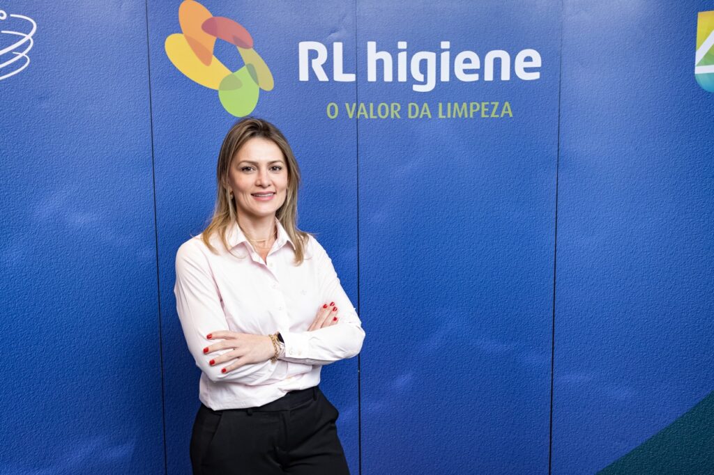 juliana lettrari em um fundo azul com a logo da rl; mulher em um fundo azul