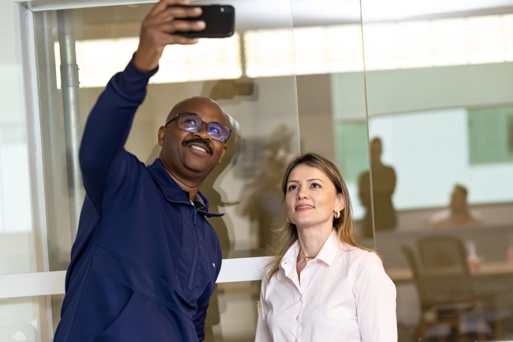 Duas pessoas tirando uma selfie; trabalhadores da empresa RL higiene