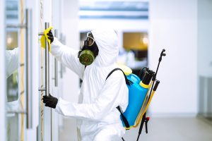 Limpeza e desinfecção do escritório para prevenir COVID-19, homem em traje de proteção de proteção lava escritório, essencial para a prevenção de contaminação do coronavírus