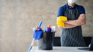 Homem fazendo limpeza profissional; pessoal de limpeza; conceito de limpeza na organização; produtos de limpeza