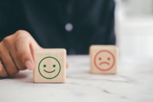 rosto feliz e triste em um quadrado, representando o equilíbrio entre os custos e a qualidade dos serviços